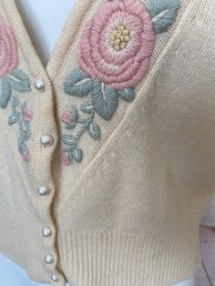 "Retro womens Evan Picone cardigan Pale pastel yellow sweater is nicely embroidered with light pink and green flowers and leaves Pearl buttons Excellent vintage condition. Slight hole at bottom front by side seam, hardly noticeable. See photo #6 (ribbed waist area) Tag size Medium 95% Lambswool 5% Nylon Measurements when laying flat across: Bust - 20\" Sleeve length - 21\" Length - 22.5\" Waist - 15\"" Vintage Embroidered Sweater For Spring, Vintage Floral Embroidered Sweater For Spring, Vintage Cream Sweater With Floral Embroidery, Fitted Cream Sweater With Floral Embroidery, Vintage Spring Sweater With Buttons, Vintage Cream Sweater For Spring, Vintage Embroidered Beige Sweater, Vintage Floral Embroidered Cardigan For Spring, Vintage Beige Embroidered Sweater