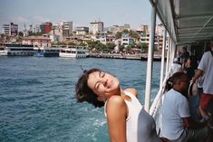 a woman standing on the side of a boat