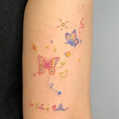 a woman's arm with colorful tattoos and butterflies on the back of her leg