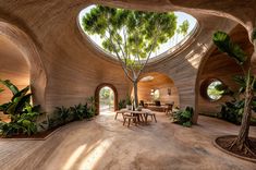 the inside of a house with circular windows and plants on either side of the room