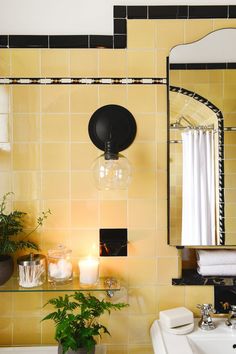 a bathroom with a sink, mirror and bathtub next to a plant on the counter