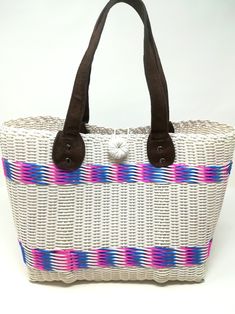 Handwoven by local artisans in Guatemala and designed by Verapaz, this tote bag is crafted from 100% recycled plastic. This colourful, practical and original tote bag is ideal for a visit to the beach, for your iPad or yoga clothes. It is a roomy essential accessory that would add a stylish touch to your outfit. Thanks to the nature and quality of the plastic it has been woven from, this tote is extremely durable and versatile. Height: 24cm Width: 37cm Depth: 15cm Handles drop: 20cm *Since our b White Handwoven Beach Bag For Travel, Eco-friendly White Beach Bag For Market, Casual Beach Bag Made From Recycled Materials, White Tote Beach Bag For Market, Eco-friendly Beach Bag With Handles For Market, Casual White Handwoven Beach Bag, Casual White Beach Bag With Leather Handles, Eco-friendly Beach Bag For Market, White Bucket Beach Bag For Market