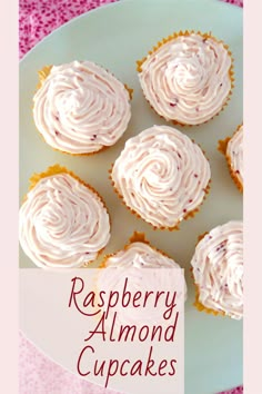 some cupcakes with white frosting are on a plate and the words raspberry almond cupcakes