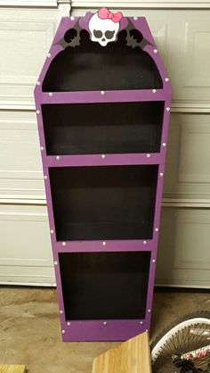 a purple book shelf sitting on top of a wooden table next to a bike tire