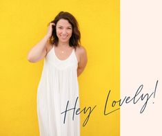 a woman standing in front of a yellow wall with the words hey lovely on it