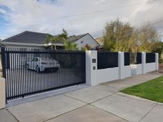 a black and white fence in front of a house with a truck parked on the driveway