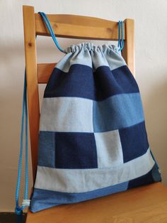 a blue and white bag sitting on top of a wooden chair