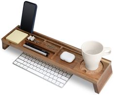 a wooden desk with a keyboard, mouse and coffee cup on it's tray