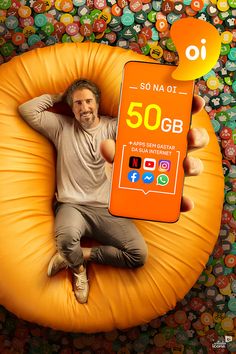 a man sitting on an inflatable chair holding up a cell phone with the number 50gb written on it