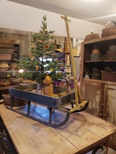 a small christmas tree is sitting on a table in a room with old furniture and other items