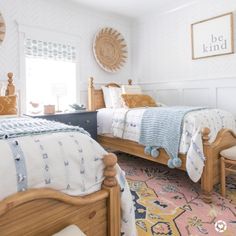 a bedroom with two beds and a rug on the floor