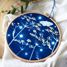 a blue and white embroidery with yellow flowers on it, next to a wooden basket