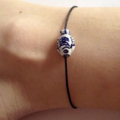 a woman's arm with a blue and white bracelet on it