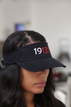 a woman wearing a black visor with the date 1911 on it's side