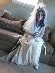 a woman in a wedding dress sitting on a couch