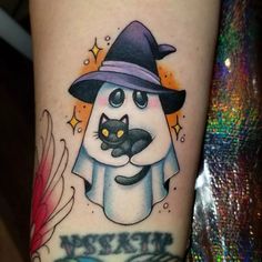 a tattoo with a cat and witch hat on it