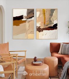 two abstract paintings hang on the wall above a chair and ottoman in a living room