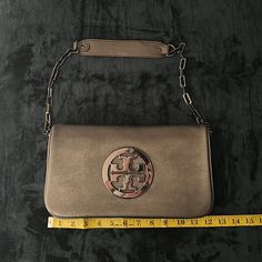 Tory Burch Large Gun-Metal Leather Bag/Purse. Size 12in X 7in. Shoulder Chain In Gun-Metal Along With Zippers And T T Logo. Beautiful Bag! Basically Brand New! No Wear Or Stains. Magnetic Closer, Along With Zipper Closers On The Inside Of The Purse To Keep Things Safely Contained Inside. Shoulder Strap Is Also Detachable. Measurements In Photos. Thanks For Looking! Please Check Out My Other Items! Silver Clutch Bags With Silver-tone Hardware, Luxury Silver Shoulder Bag With Magnetic Closure, Silver Leather Crossbody Evening Bag, Designer Silver Clutch Bag, Silver Crossbody Shoulder Bag With Magnetic Closure, Classic Silver Crossbody Bag, Silver Rectangular Bag With Magnetic Closure, Rectangular Silver Bag With Magnetic Closure, Classic Silver Shoulder Bag With Detachable Strap