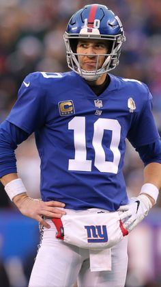 a football player standing on the field with his hands on his hips and wearing a helmet