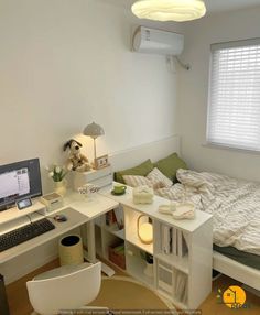 a bedroom with a bed, desk and computer on top of it in front of a window