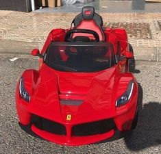 a red toy car sitting on top of a street