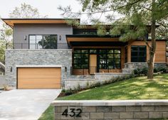 a modern house with two garages and stone steps leading up to the front door