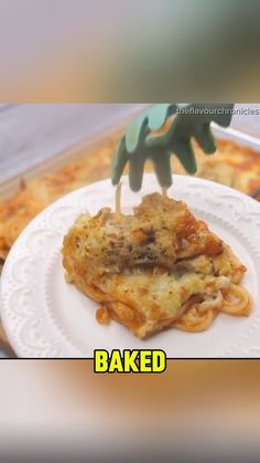 a white plate topped with pasta and meat covered in sauce