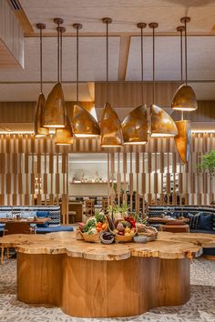 a large wooden table sitting in the middle of a room filled with chairs and lamps