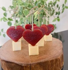 four heart shaped cheese sticks on top of a piece of wood