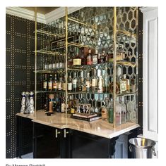 a bar with lots of liquor bottles on the top shelf and shelves below it,