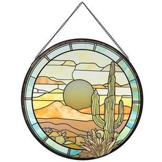 a stained glass window with a cactus and sun in the sky on it's side