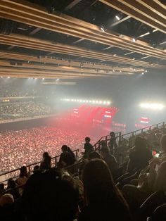 an arena filled with lots of people watching a concert