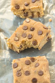 two pieces of chocolate chip cookie sitting on top of aluminum foil