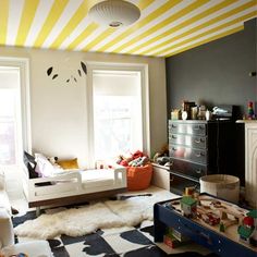 a child's room with yellow and white stripes painted on the ceiling, furniture and rugs