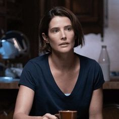 a woman sitting in front of a kitchen counter