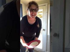 a woman holding a frisbee in her right hand and smiling at the camera