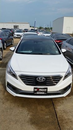 a white car parked in a lot next to other cars