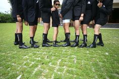 a group of men standing next to each other on top of a lush green field