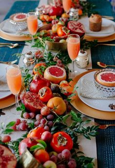 a long table is set with fruit and wine for a festive dinner or brunch