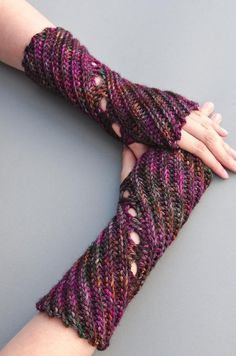 a woman's hand is wrapped in knitted fingerless gloves