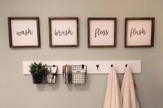 three framed pictures hanging on the wall above a sink and towel rack with two plants