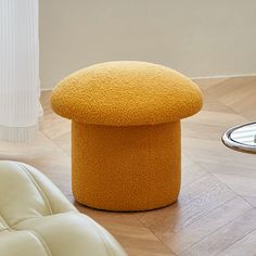 a yellow foot stool sitting on top of a hard wood floor