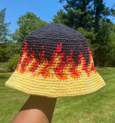 a person wearing a crocheted hat with trees in the background and grass on both sides