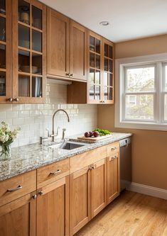 a kitchen with wooden cabinets and marble counter tops