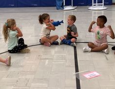 four children sitting on the floor playing with toys