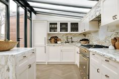 a kitchen with marble counter tops and white cabinets