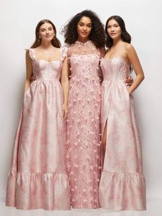 three women in pink dresses standing next to each other