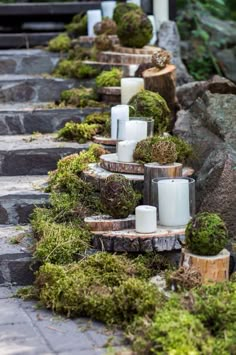 moss covered candles are lined up on stone steps