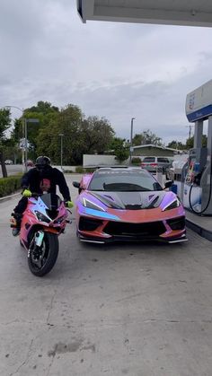 a person on a motorcycle next to a car at a gas station