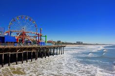 a ferris wheel sitting on top of a pier next to the ocean